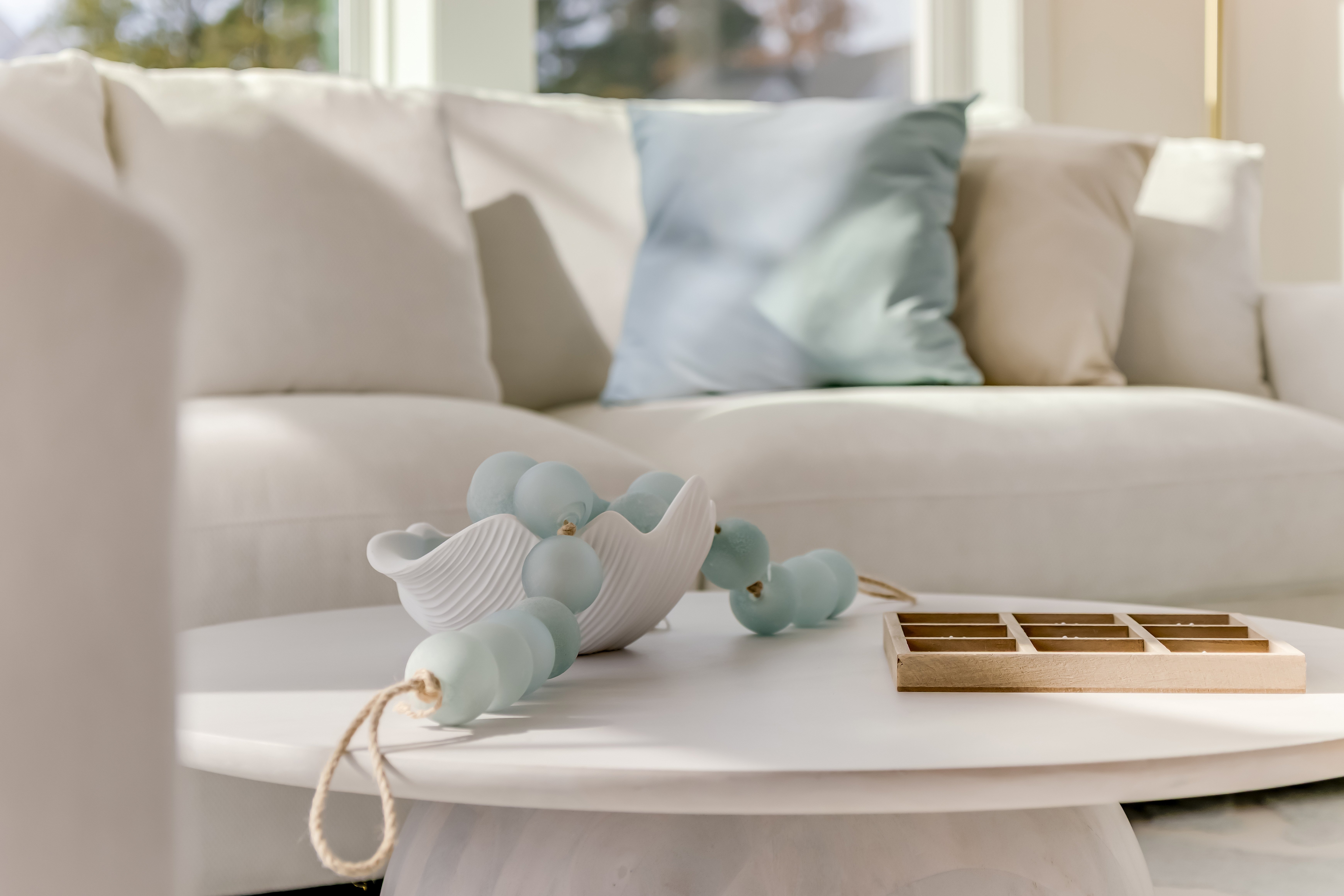 A close-up look of a coastal living space complete with simple centerpieces on the coffee table