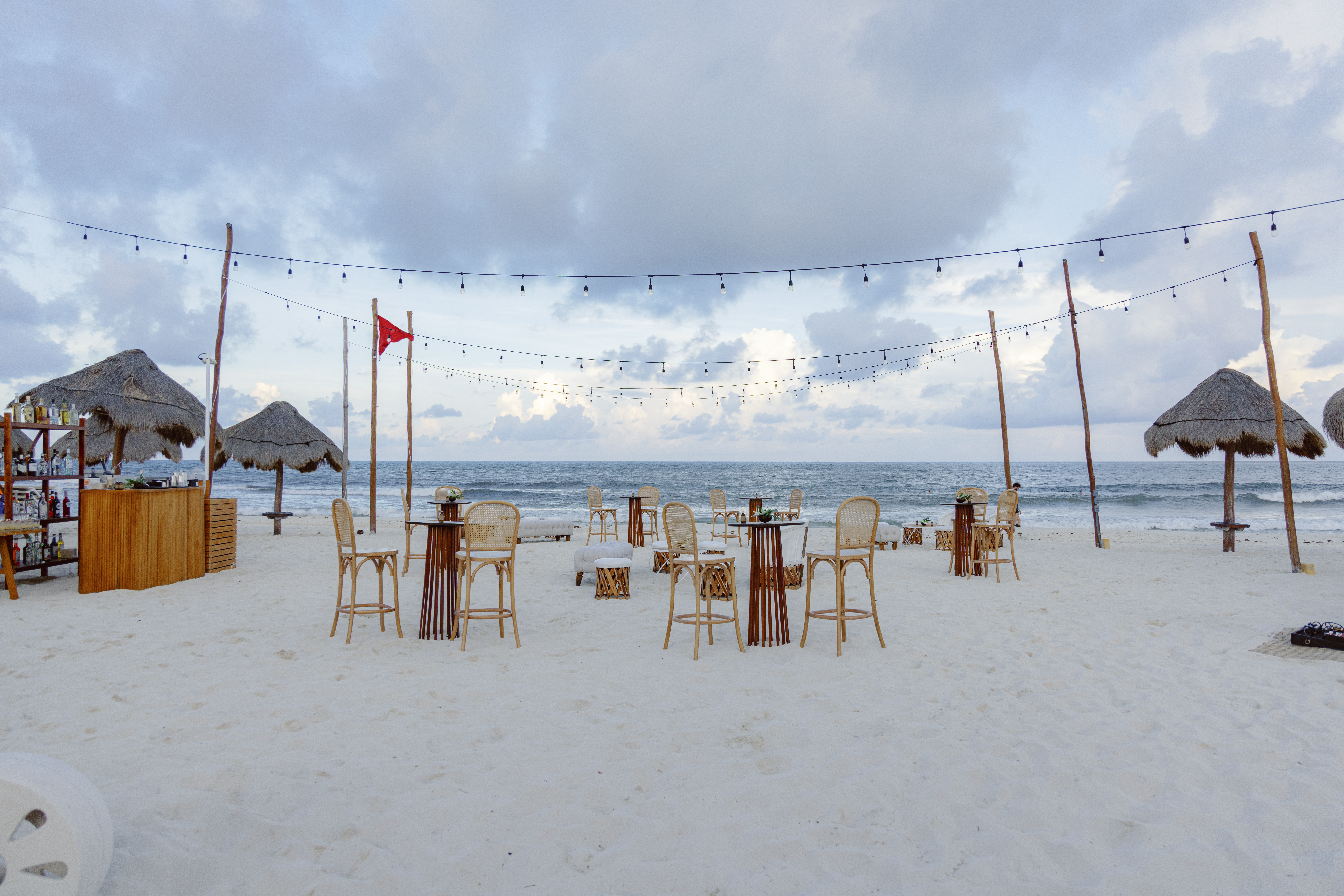 Imagine a stunning beach scene with dining tables under colorful umbrellas, offering shade and ocean viewsan ideal spot for a relaxing meal in good company, perfect for creating lasting memories
